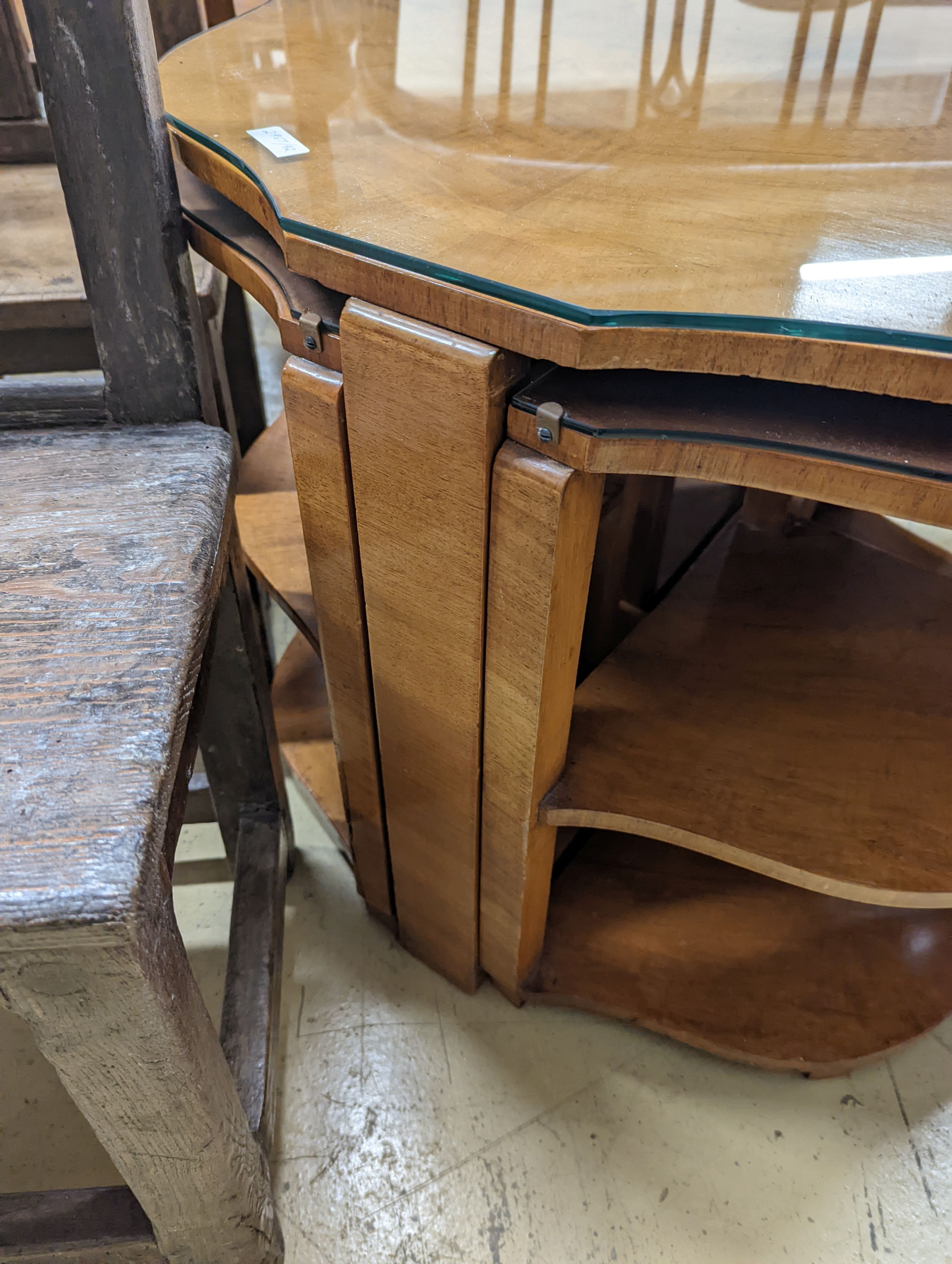 An Art Deco style cross banded walnut nest of tables of circular serpentine form, diameter 72cm, height 54cm